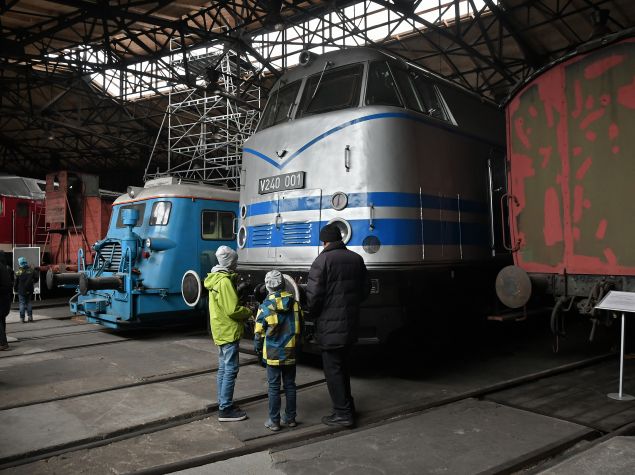 Eine Familie vor großen Lokomotiven im Eisenbahndepot des Verkehrsmuseums