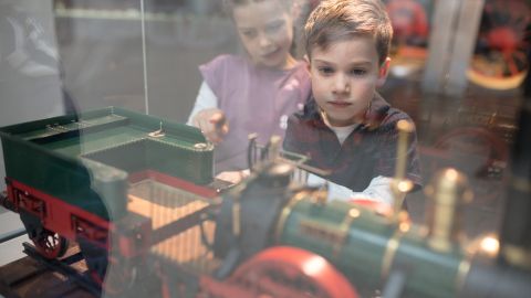 Kinder betrachten Modelle in der Ausstellung Schienenverkehr