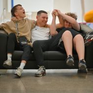 Drei jugendliche Jungs auf einer Couch, die sich freuen im Museum zu sein