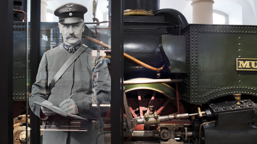 Bild eines Deutschen Reichsbahners vor der grünen Dampflokomotive Muldental