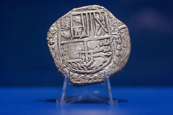 Alte Münze, auf der ein Schiff mit Segel abgebildet ist.