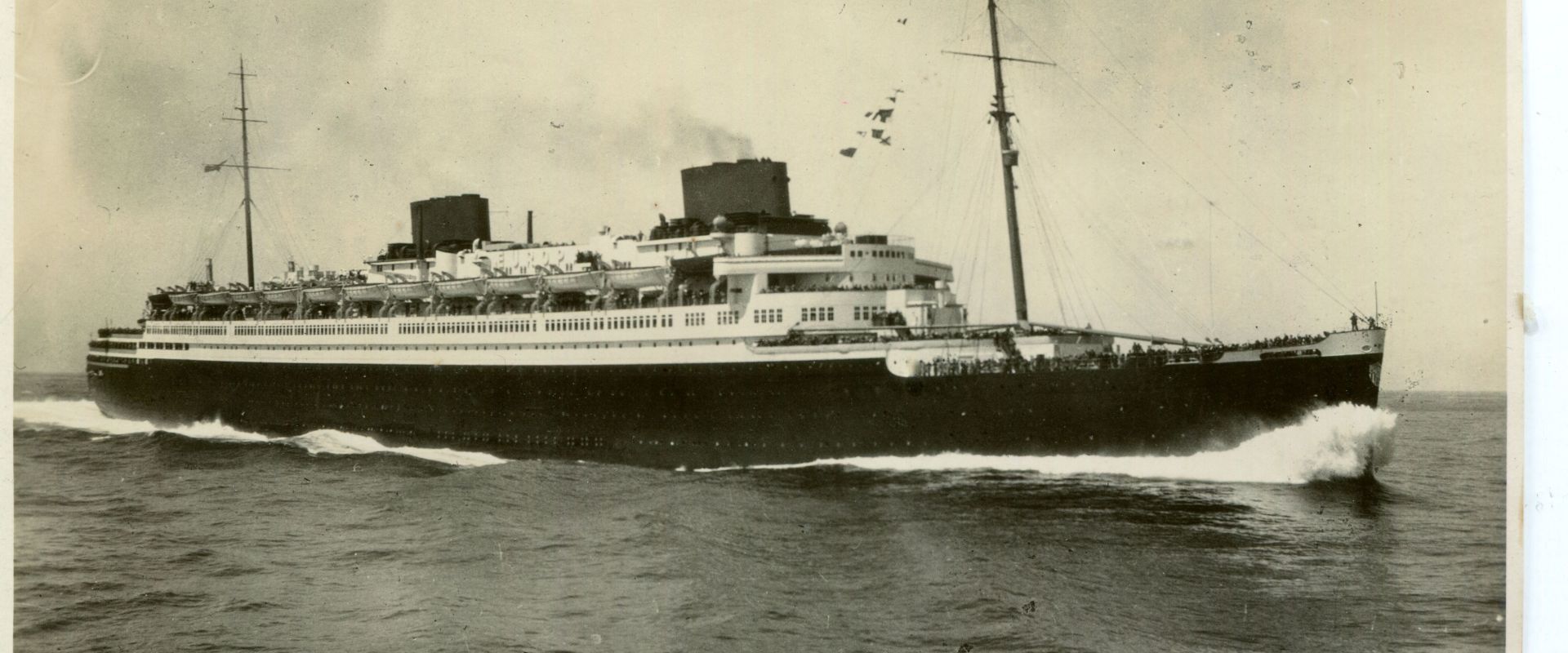 Ein altes schwarz-weiß Foto mit einem Schiff auf hoher See.