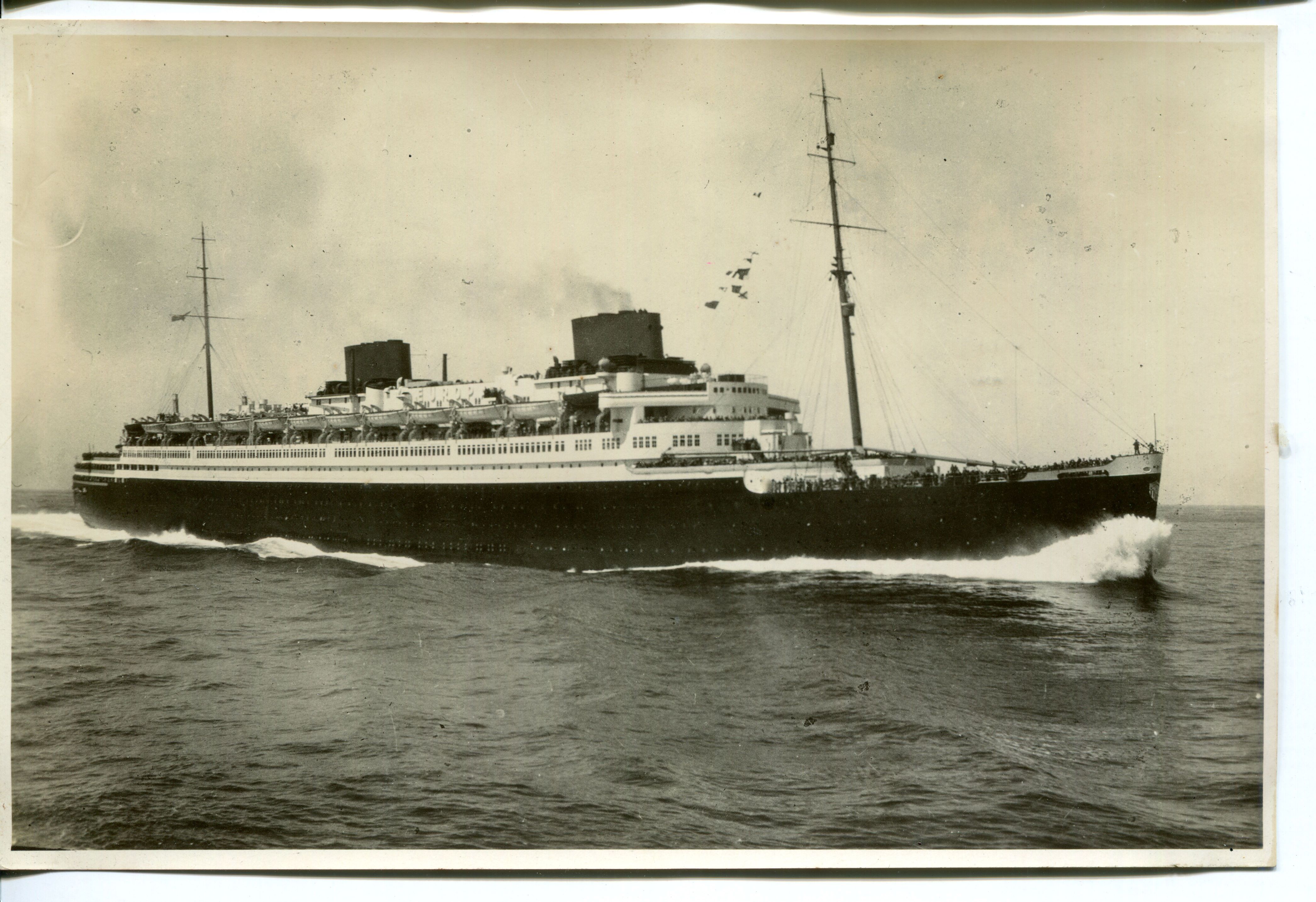 Ein altes schwarz-weiß Foto mit einem Schiff auf hoher See.